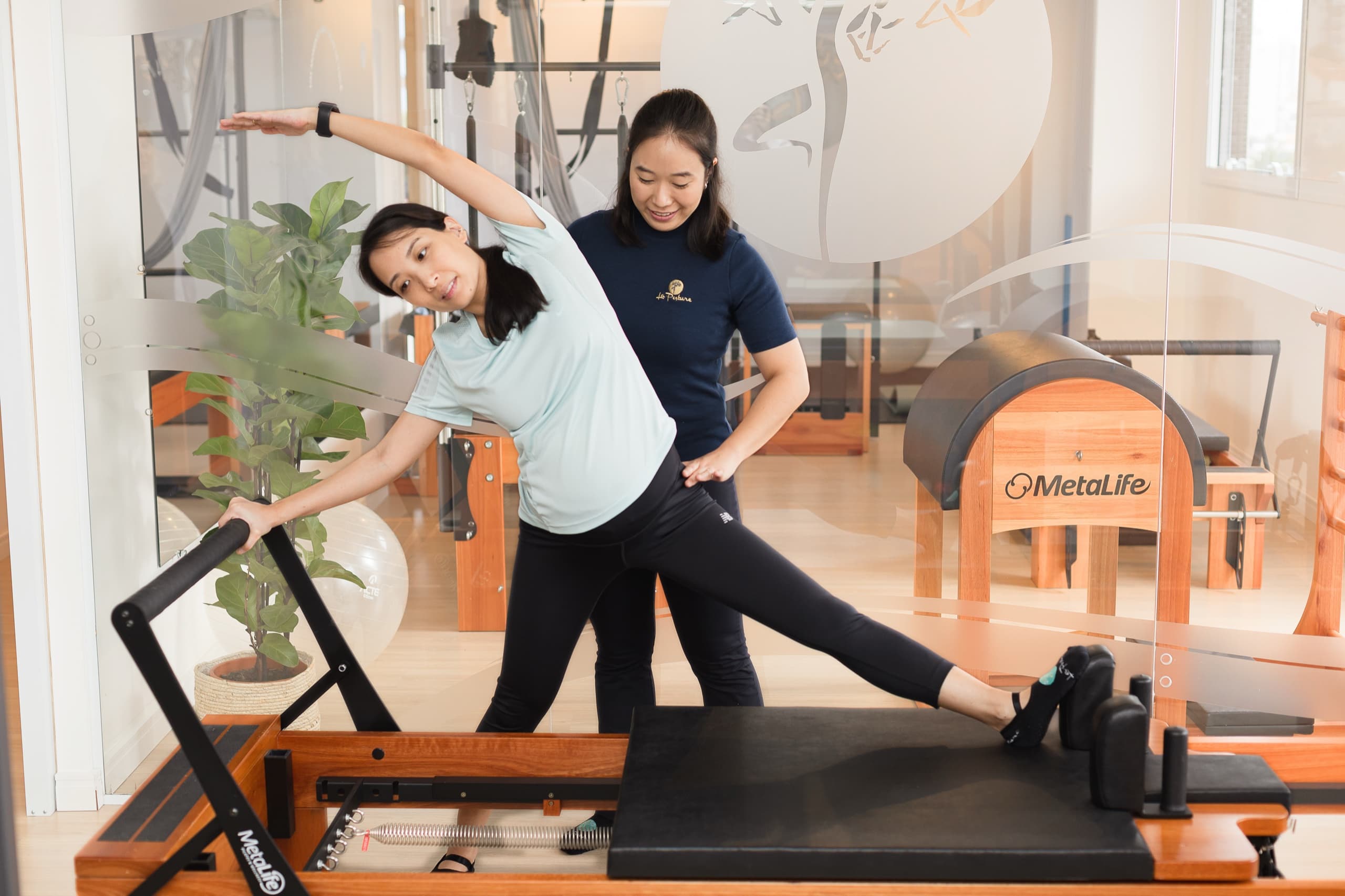 Fisioterapeuta especialista La Posture conduzindo sessão de movimento consciente no Reformer com alinhamento postural cuidadoso