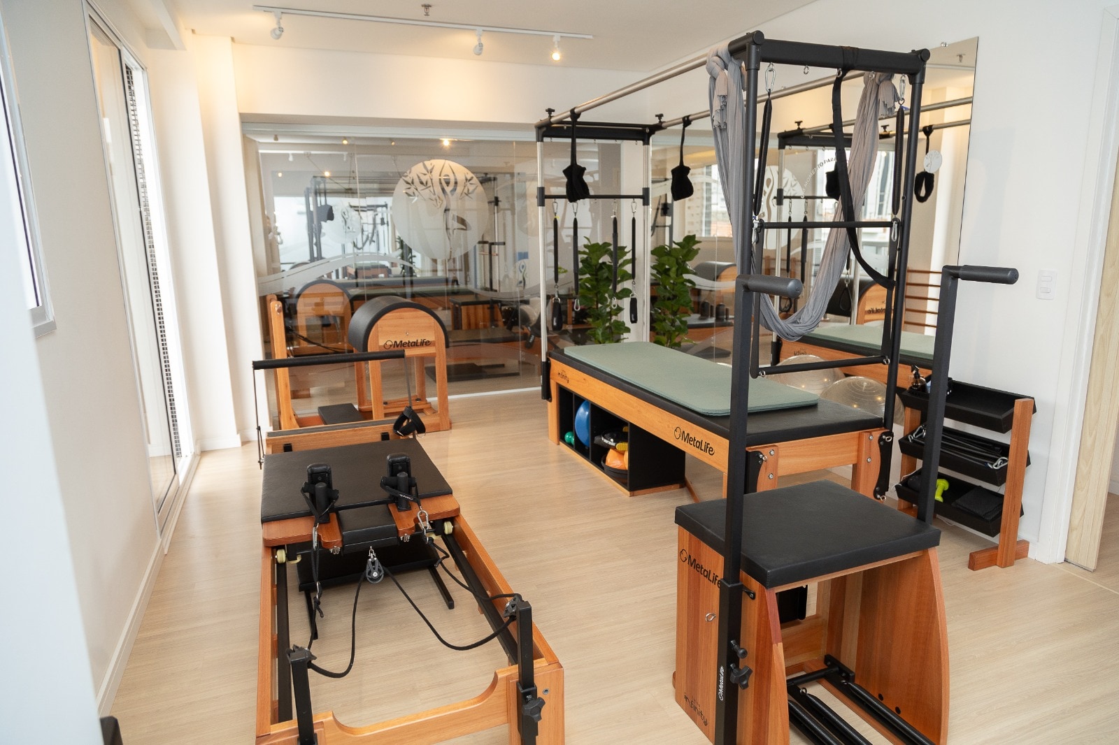 Estúdio de Pilates da Clínica La Posture com aparelhos completos e iluminação acolhedora